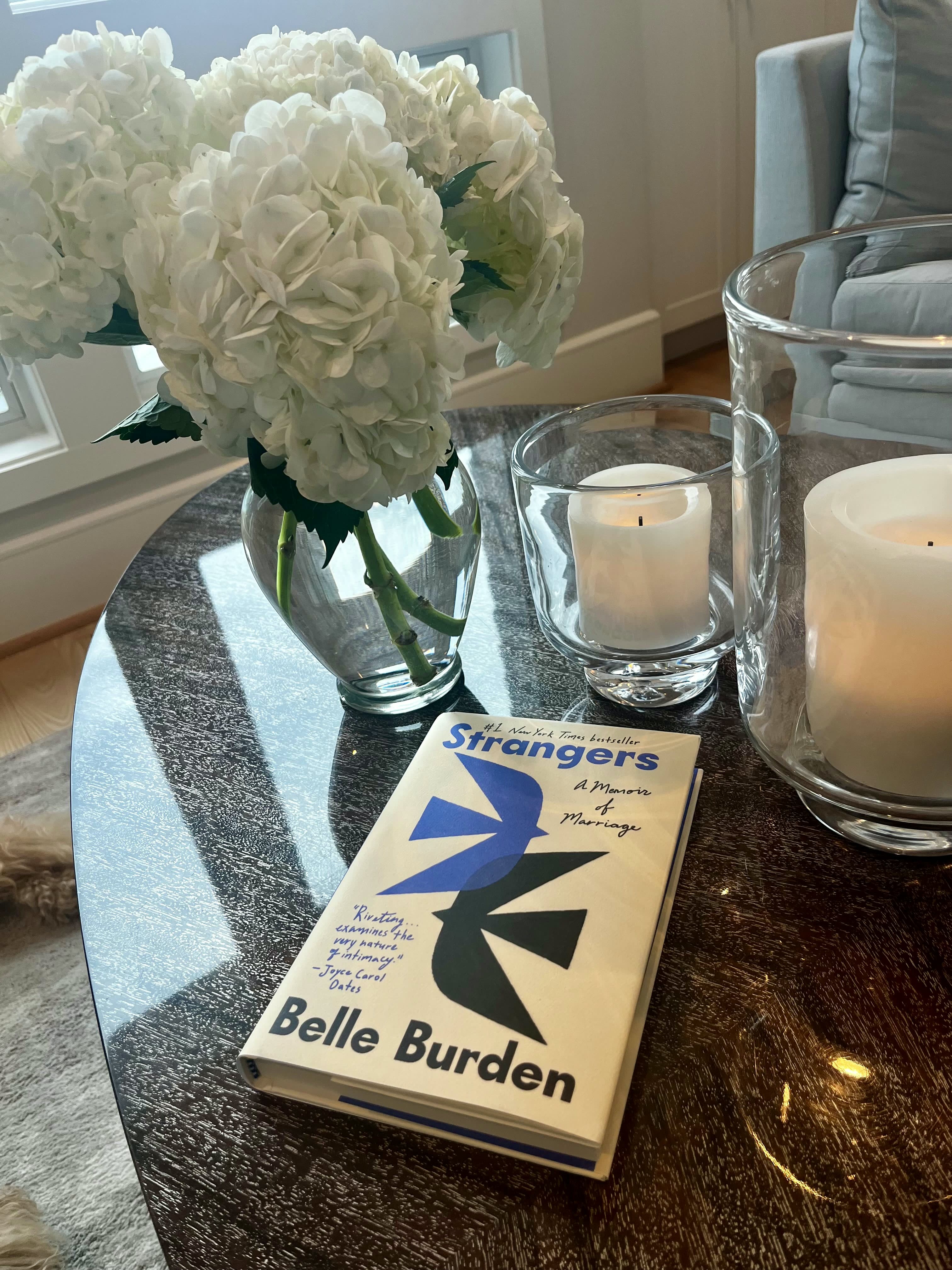 Strangers by Belle Burden beside hydrangeas and candles